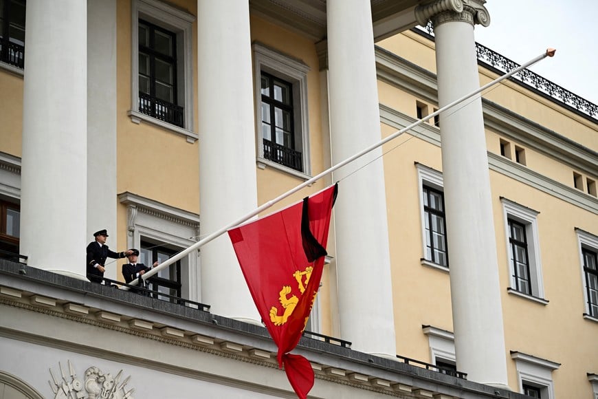 Palace workers put a flag at half-mast at the Royal Palace, following the death of Norway's King Harald in Oslo, Norway, August 28, 2026. REUTERS/Dylan Martinez