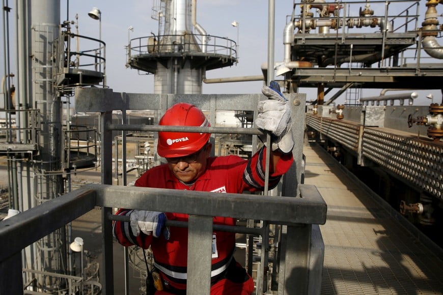 FILE PHOTO: An oilfield worker walks down the stairs at PDVSA's Jose Antonio Anzoategui industrial complex in the state of Anzoategui, April 15, 2015. Venezuela has launched talks this month on a novel plan to blend the country's heavy crude with light oil from other OPEC allies, seeking to create a new variety that can compete against swelling U.S. and Canadian supplies. The proposal, which would expand on a pilot scheme involving Algerian oil last year, envisions supplying refineries built for medium-grade crudes rather than the light oil that has become plentiful as a result of the North American shale boom, said the head of state oil company PDVSA, Eulogio del Pino. Picture taken on April 15, 2015. REUTERS/Carlos Garcia Rawlins/File Photo