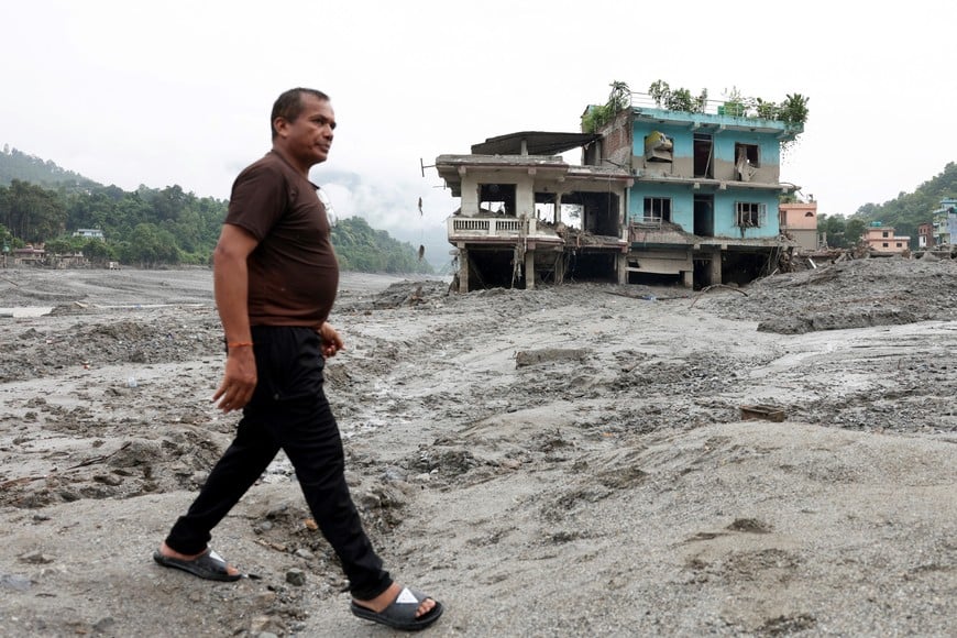 A man walks past a damaged house following the flash floods and mudslide, at Devighat, Nuwakot district, Nepal, August 29, 2026. REUTERS/Adnan Abidi