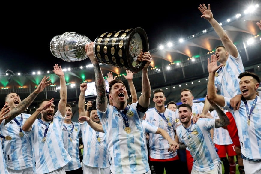 FILE PHOTO: Soccer Football - Copa America 2021 - Final - Brazil v Argentina - Estadio Maracana, Rio de Janeiro, Brazil - July 10, 2021 Argentina's Lionel Messi and teammates celebrate winning the Copa America with the trophy REUTERS/Amanda Perobelli/File Photo