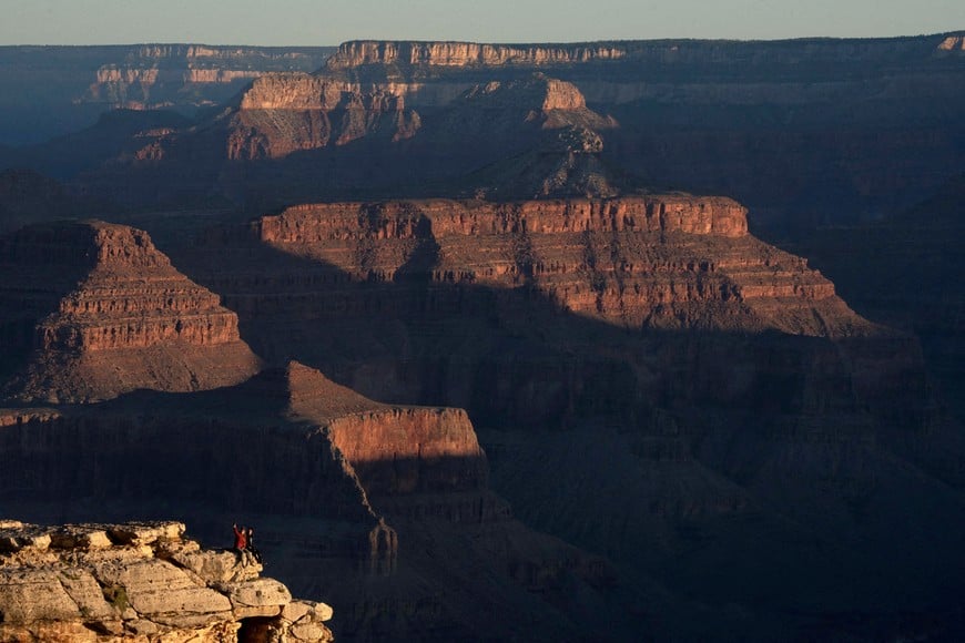 FILE PHOTO: Tourists use their mobile phone while the early morning sunlight hits canyon ridges as seen from the south rim of Grand Canyon National Park near Tusayan, Arizona, U.S., May 16, 2025. REUTERS/Rebecca Noble TPX IMAGES OF THE DAY/File Photo