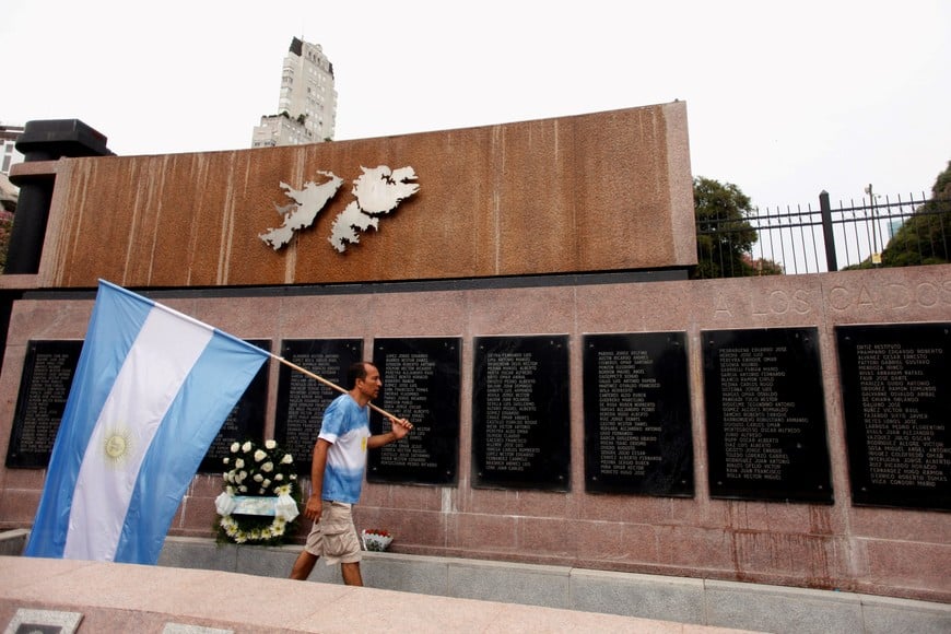 A man carries Argentina's national flag in front of the wall with names of those who died in the 1982 war between Britain and Argentina in the Falkland Islands, known to Argentines as 'Malvinas', at the memorial dedicated to them as today marks the 35th anniversary of the war, in Buenos Aires, Argentina, April 2, 2017. REUTERS/Martin Acosta buenos aires 35 años aniversario de la guerra de islas malvinas monumento malvinas homenaje a los soldados caidos