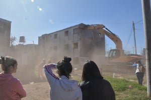 Las vecinas miran cómo demuelen sus antiguas viviendas. Archivo.