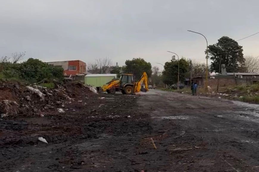 Un operario maneja una retroexcavadora, sacando montañas de mugre. Archivo