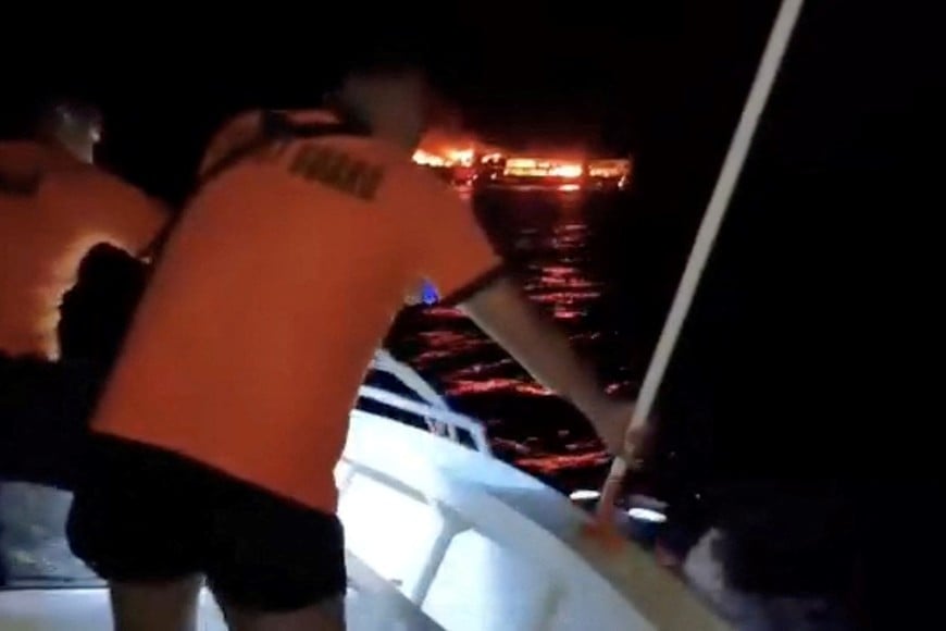Members of the Philippine coast guard work to rescue a passenger in the water while MV June Aster burns after a fire broke out on the ferry, off the coast of Palawan, Philippines, in this screengrab taken from a handout video released on September 9, 2026. Philippine Coast Guard/Handout via REUTERS THIS IMAGE HAS BEEN SUPPLIED BY A THIRD PARTY. MANDATORY CREDIT. NO RESALES. NO ARCHIVES