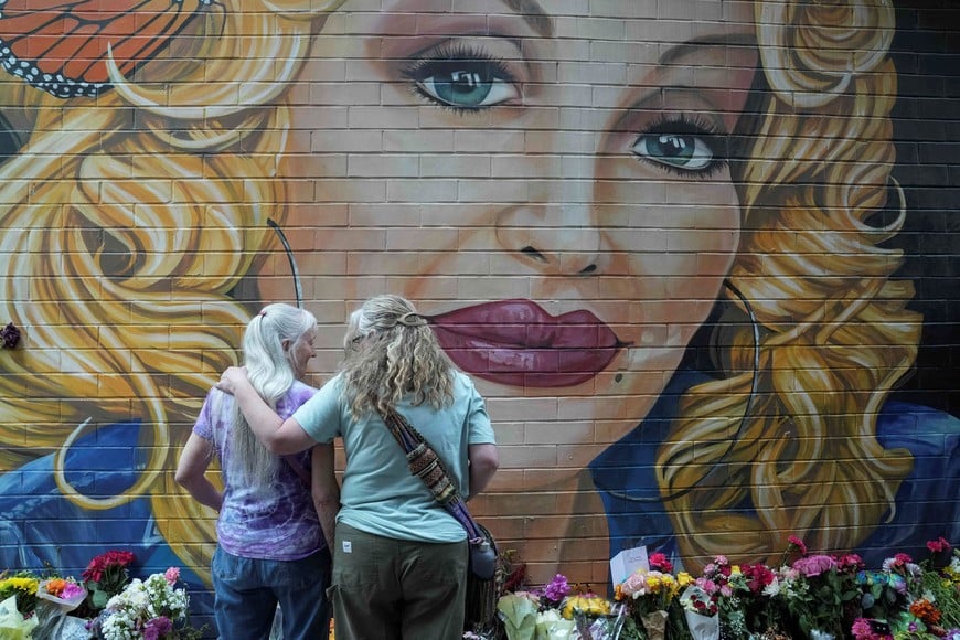 People gather by a mural to pay their respects to late country singer Dolly Parton a day after her death was announced, in Knoxville, Tennessee, U.S., August 26, 2026. REUTERS/Megan Varner TPX IMAGES OF THE DAY