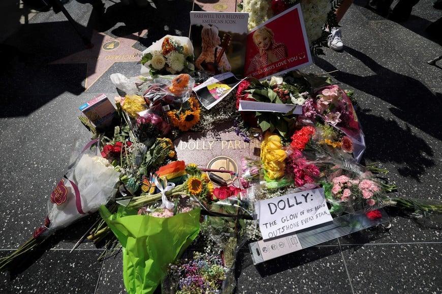 Flowers and signs lie at the star of Dolly Parton on the Hollywood Walk of Fame after it was announced that the country music icon died aged 80, in Los Angeles, California, U.S., August 25, 2026. REUTERS/Mario Anzuoni