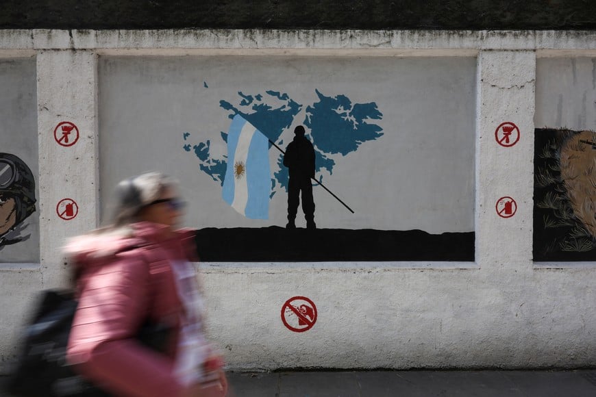 A woman walks past a mural depicting a soldier holding an Argentine flag in front of a map of the Falkland Islands, known in Argentina as the Islas Malvinas, commemorating the 1982 war between Britain and Argentina over the Falklands, in Buenos Aires, Argentina, September 15, 2026. REUTERS/Alessia Maccioni