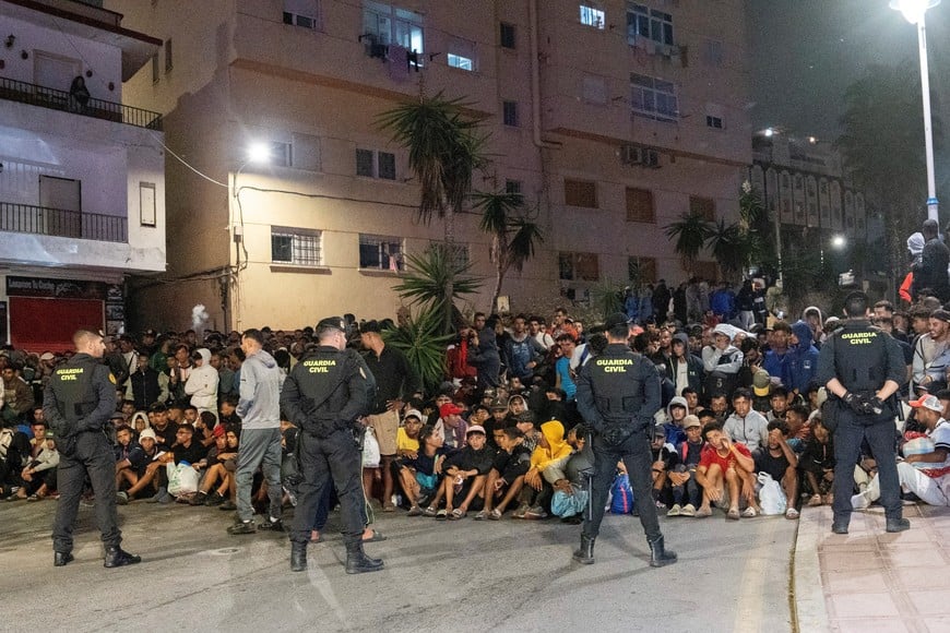 Police escort migrants from Benitez Beach to be relocated to the camp set up at the port of Ceuta, Spain, September 18, 2026. REUTERS/ Anna Surinyach