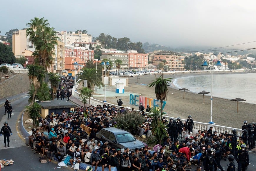 Police escort migrants from Benitez Beach to be relocated to the camp set up at the port of Ceuta, Spain, September 18, 2026. REUTERS/ Anna Surinyach