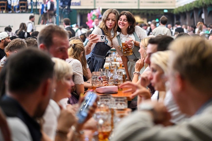 Attendees take a selfie as they enjoy the official opening day of the 191st Oktoberfest, the world's largest beer festival, in Munich, Germany, September 19, 2026. REUTERS/Fariha Farooqui TPX IMAGES OF THE DAY