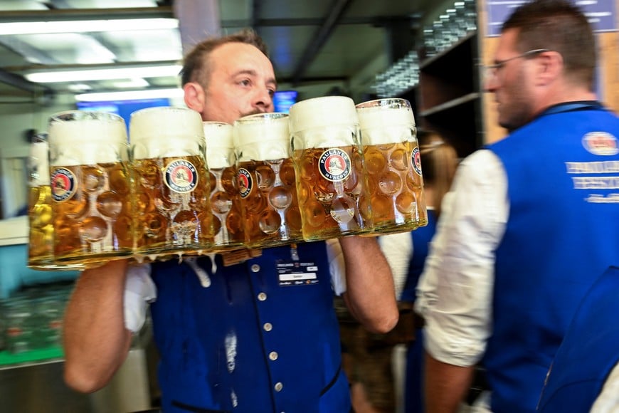 A waiter carries mugs of beer during the official opening day of the 191st Oktoberfest, the world's largest beer festival in Munich, Germany, September 19, 2026. REUTERS/Angelika Warmuth