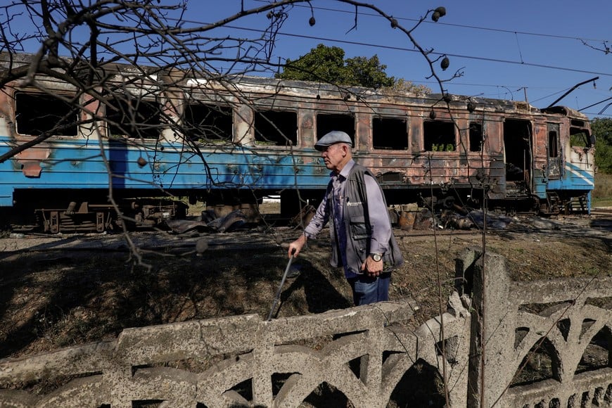 A resident walks next to a suburban train which was hit by a Russian drone strike, amid Russia's attack on Ukraine, in Kharkiv region, Ukraine September 18, 2026. REUTERS/Sofiia Gatilova