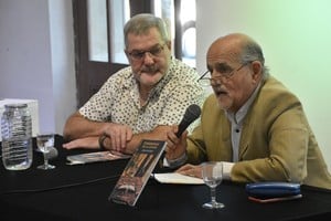Néstor Fenoglio y Julio Gómez (micrófono en mano), en 2023 durante la presentación del libro "Ceremonias de la locura", del último de los nombrados. "Si bien los temas de los poemas son variados, la forma y estructura de cada poema en sí mismo hace gala del uso de los recursos lingüísticos propios de la poética española, en versos firmes y decididos, a la vez que breves y elocuentes (...)", dice la autora sobre esta obra.