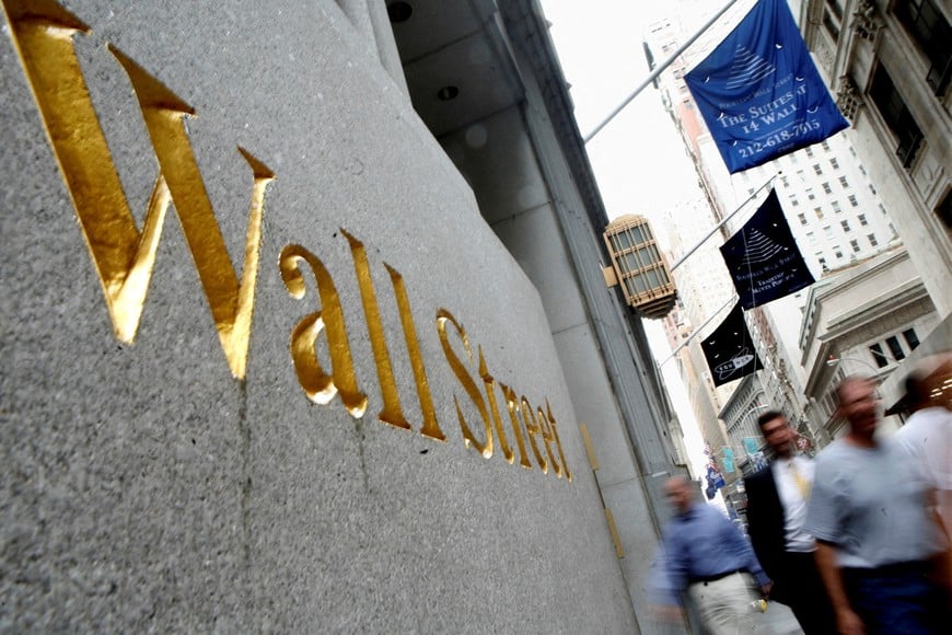 FILE PHOTO: People walk along Wall Street near the New York Stock Exchange July 13, 2007. REUTERS/Brendan McDermid/File Photo