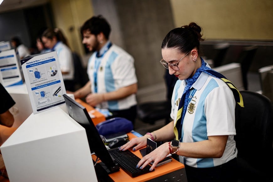 Aerolineas Argentinas employees check in passengers as Argentina fans scramble to board the last flights to New York to watch the World Cup final against Spain on Sunday in Ezeiza International Airport, Buenos Aires Province, Argentina, July 17, 2026. REUTERS/Tomas CUESTA