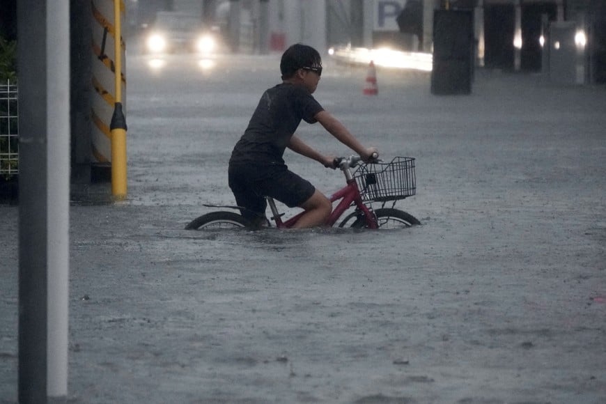 A boy cycles through a flooded street as Typhoon Dujuan brings heavy rain, in Ichikawa, Chiba Prefecture, Japan, September 21, 2026 in this photo taken by Kyodo. Kyodo/via REUTERS ATTENTION EDITORS - THIS IMAGE HAS BEEN SUPPLIED BY A THIRD PARTY. MANDATORY CREDIT. JAPAN OUT. NO COMMERCIAL OR EDITORIAL SALES IN JAPAN.