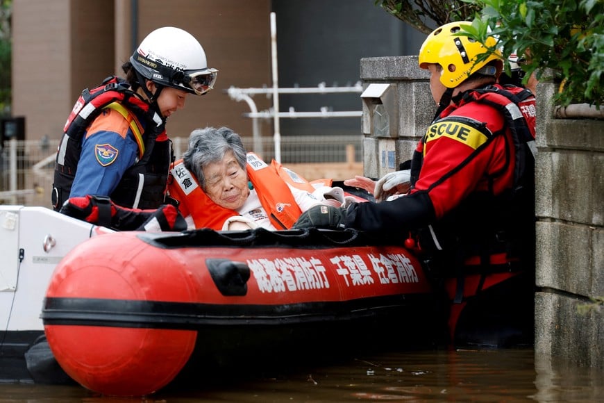 Firefighters transport an elderly woman by boat from a flooded area after Typhoon Dujuan brought torrential rain to Sakura, Chiba prefecture, Japan, September 22, 2026. REUTERS/Kim Kyung-Hoon TPX IMAGES OF THE DAY