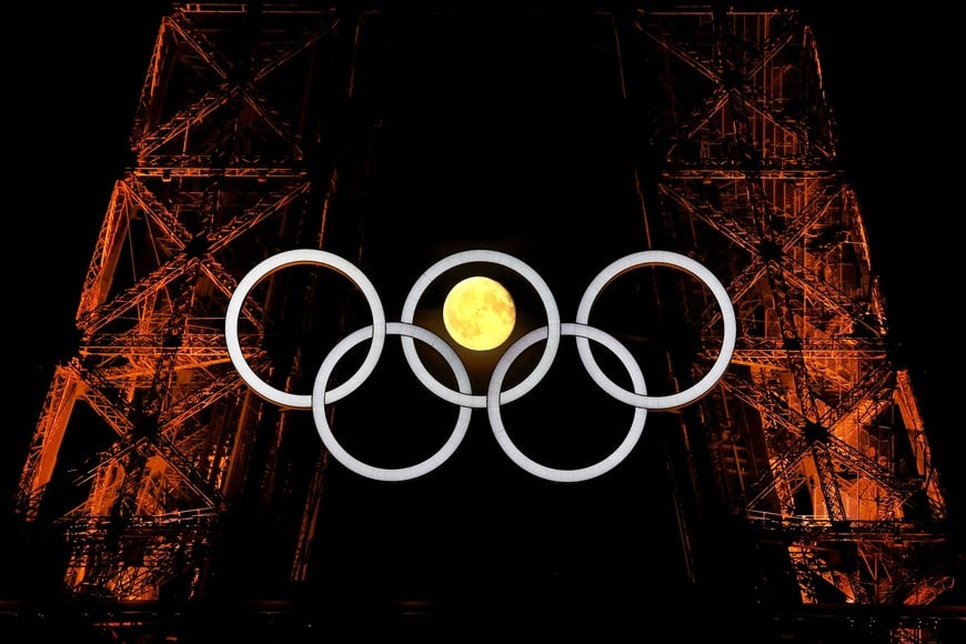 The moon is pictured with the Olympic rings on the Eiffel Tower ahead the Paris 2024 Olympic and Paralympic Games in Paris, France, July 23, 2024. REUTERS/Kai Pfaffenbach TPX IMAGES OF THE DAY
