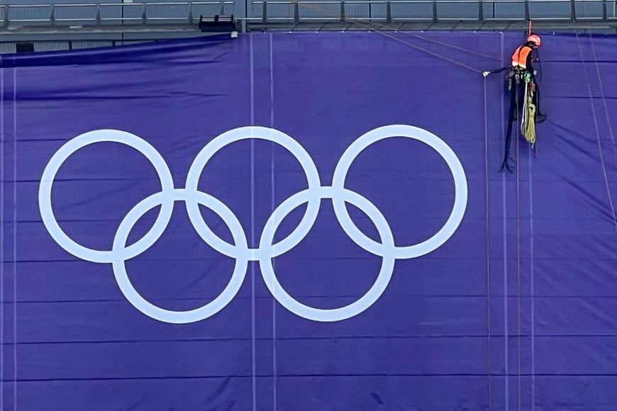 An industrial climber works on the facade of Stade de France stadium ahead the Paris 2024 Olympic and Paralympic Games in Paris, France, July 13, 2024. REUTERS/Fabrizio Bensch
