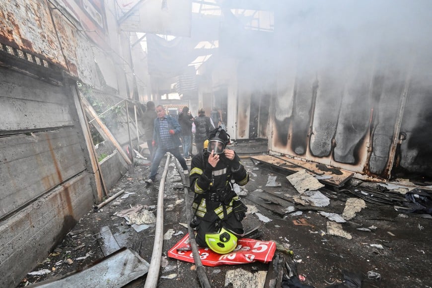 A firefighter works at the site of a damaged market hit during a Russian drone strike, amid Russia's attack on Ukraine, in Zaporizhzhia, Ukraine September 26, 2026. REUTERS/Stringer