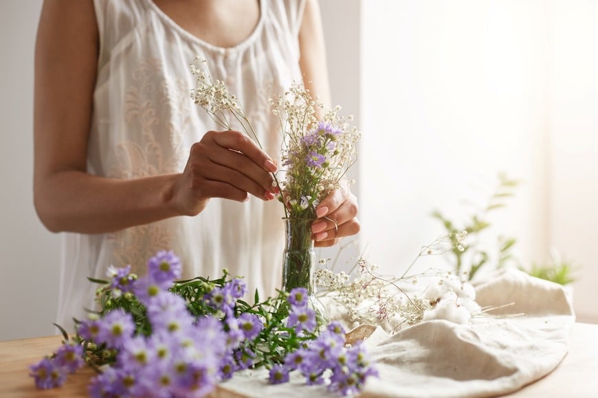 Close up photo of young female florist making tender bouquet at workplace. Copy space.