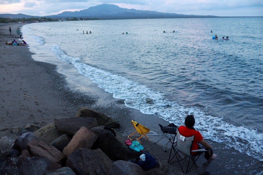 A person sits on the beach as Hurricane Polo approaches Baja California Sur, in Loreto, Mexico, September 27, 2026. REUTERS/Raquel Cunha