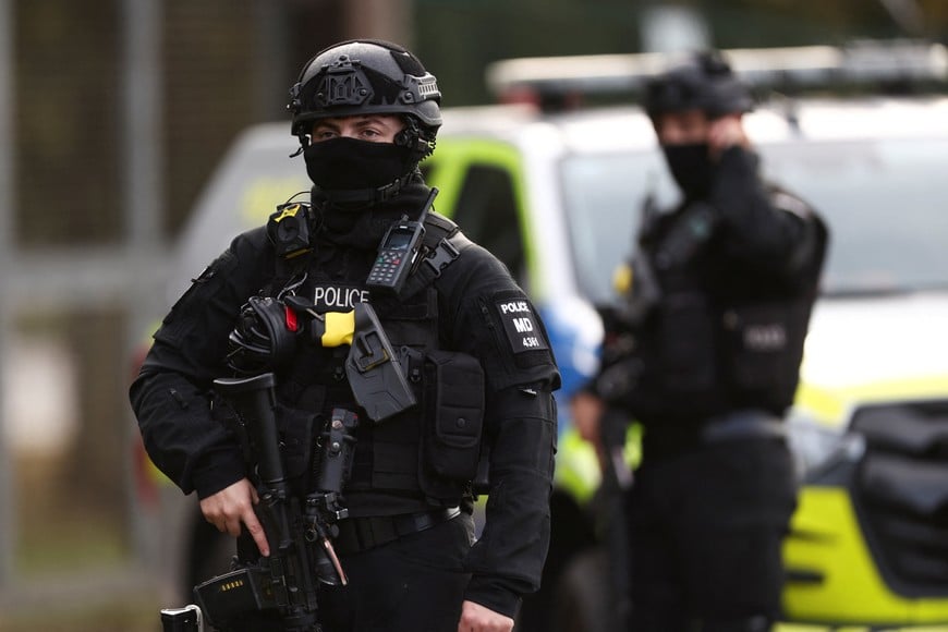 An armed police officer stands guards on a road outside the perimeter of the RAF Fairford airbase, after police declared a major incident at the base after several men were arrested on suspicion of offences under the Explosives Act, in Fairford, Gloucestershire, Britain, September 28, 2026. REUTERS/Toby Shepheard