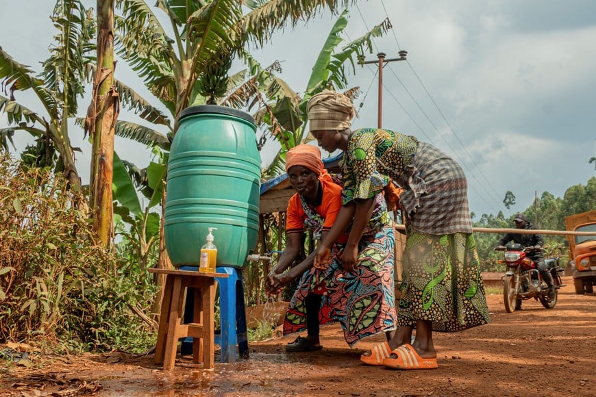 Congolese women sanitize their hands at a washing station erected by Wazalendo fighters as part of efforts to raise public awareness about measures to prevent the spread of Ebola, as aid agencies intensify efforts to contain a new Ebola outbreak involving the Bundibugyo strain in the outskirts of Butembo, North Kivu province, Democratic Republic of Congo, September 14, 2026. REUTERS/Gradel Muyisa Mumbere