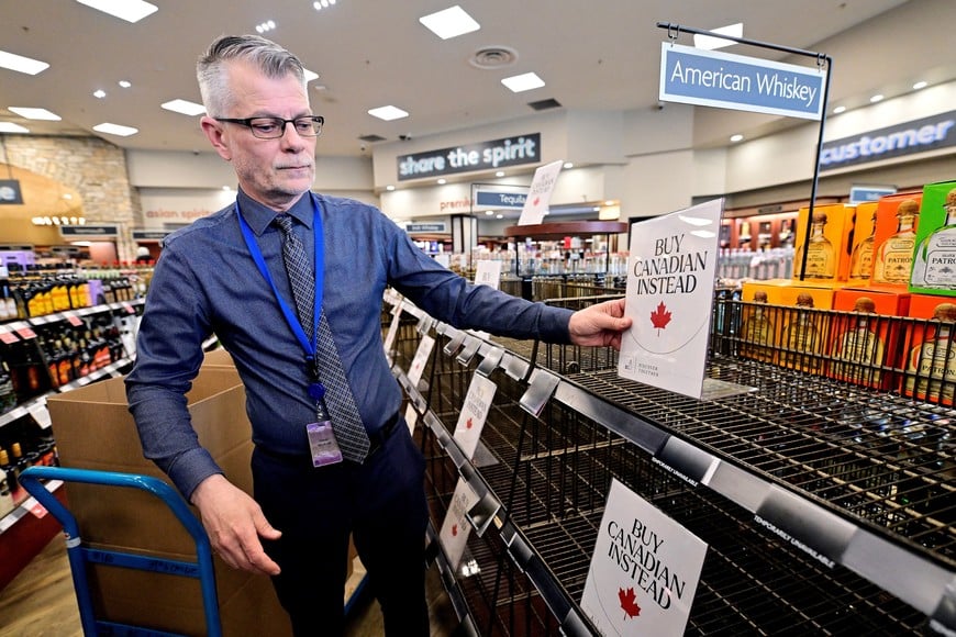 FILE PHOTO: Senior Manager Trevor Hill places a Buy Canadian Instead sign in the American Whiskey section at the BC Liquor in Vancouver, British Columbia, Canada March 10, 2025. REUTERS/Jennifer Gauthier/File Photo