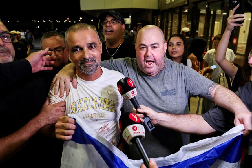 Yaniv Hayun, one of the men who helped incapacitate the attacker on the FlyDubai aircraft bound for Israel from the United Arab Emirates, which was diverted to Saudi Arabia following an emergency signal, holds an Israeli flag after arriving at the Ben Gurion International Airport, in Lod, near Tel Aviv, Israel, September 30, 2026. REUTERS/Ammar Awad