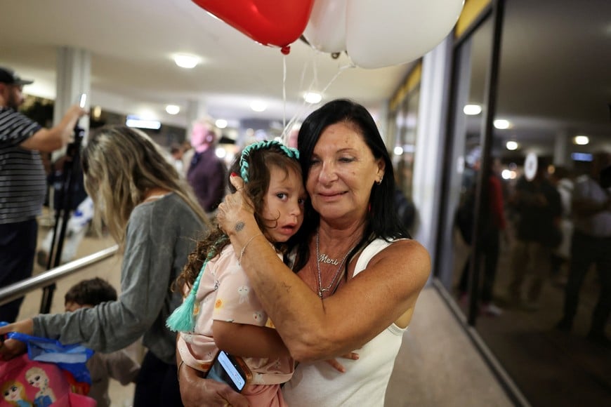 A woman carries a child while holding balloons as passengers who were on the FlyDubai aircraft bound for Israel from the United Arab Emirates, which was diverted to Saudi Arabia following an emergency signal, arrive at the Ben Gurion International Airport, in Lod, near Tel Aviv, Israel, September 30, 2026. REUTERS/Ammar Awad TPX IMAGES OF THE DAY