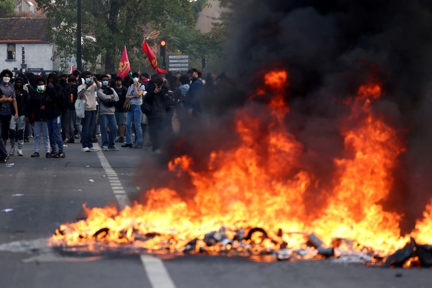 French high school and university students stand near burning garbage bins amid clashes during a protest to demand the hiring of substitute teachers, increased resources and better learning conditions, and to support the ongoing high-school student movement in the Seine-Saint-Denis department, in Saint-Denis near Paris, France, October 1, 2026. REUTERS/Abdul Saboor