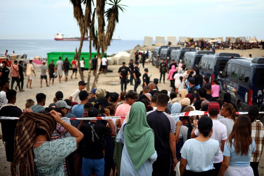 Migrants wait in line to receive food from the Red Cross at Trampolin Beach following recent mass crossings of migrants from Morocco to Ceuta, Spain, September 30, 2026. REUTERS/Pedro Nunes
