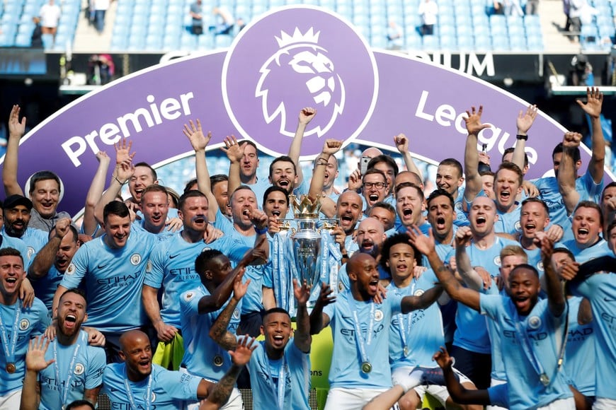 FILE PHOTO: Soccer Football - Premier League - Manchester City vs Huddersfield Town - Etihad Stadium, Manchester, Britain - May 6, 2018   Manchester City manager Pep Guardiola celebrates with the trophy, players and staff after winning the Premier League title   Action Images via Reuters/Carl Recine    EDITORIAL USE ONLY. No use with unauthorized audio, video, data, fixture lists, club/league logos or "live" services. Online in-match use limited to 75 images, no video emulation. No use in betting, games or single club/league/player publications.  Please contact your account representative for further details./File Photo