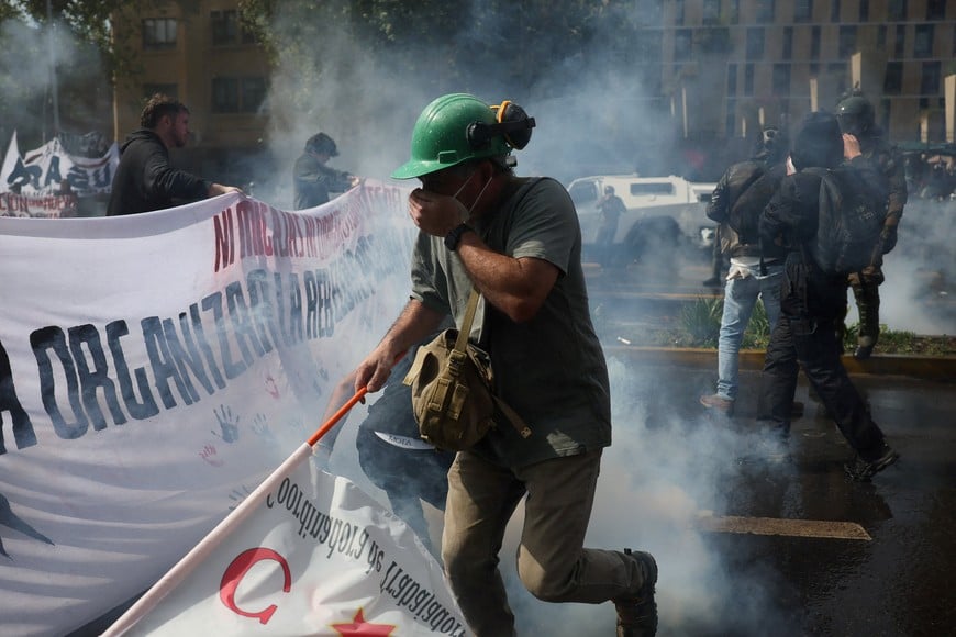 A demonstrator covers their mouth amid tear gas during a protest against President Jose Antonio Kast's government policies, in Santiago, Chile, October 1, 2026. REUTERS/Pablo Sanhueza