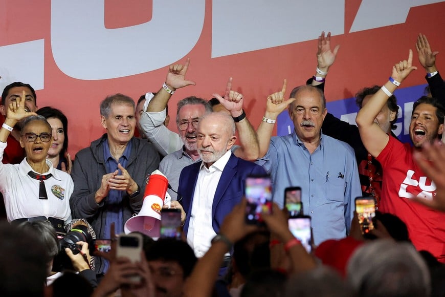 Supporters gesture as Brazilian President and Workers' Party (PT) candidate for re-election, Luiz Inacio Lula da Silva, looks on after the country's electoral authority said Flavio Bolsonaro will face Lula in the runoff of a presidential election in Sao Paulo, Brazil, October 4, 2026. REUTERS/Amanda Perobelli