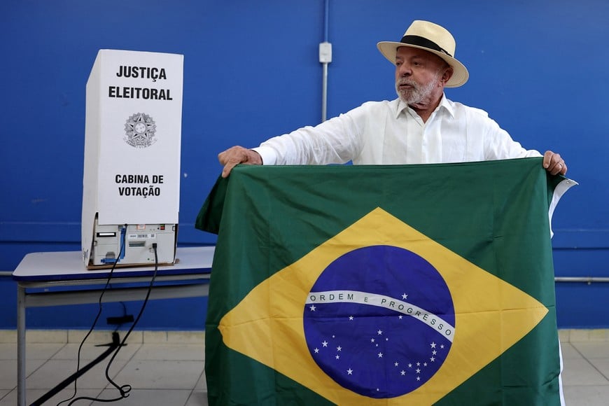 Brazilian President and Workers' Party (PT) candidate for re-election Luiz Inacio Lula da Silva holds the national flag as he arrives to vote in the general election in Sao Bernardo do Campo, Brazil, October 4, 2026. REUTERS/Amanda Perobelli
