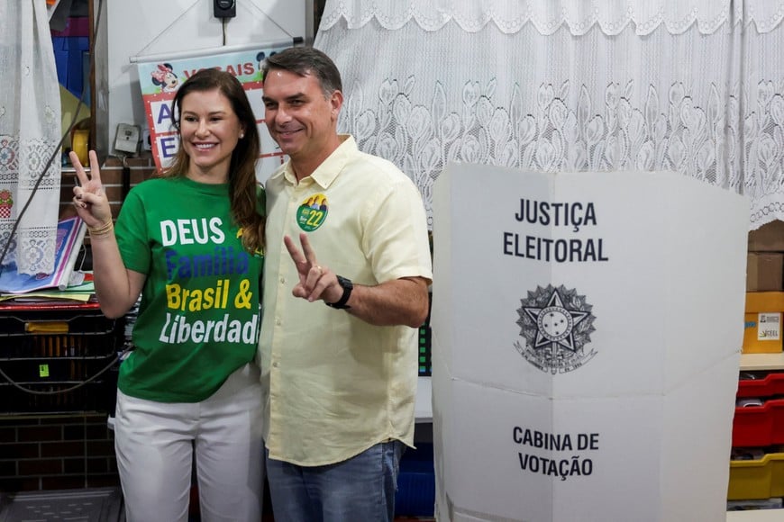 Brazil's presidential candidate Flavio Bolsonaro of the Liberal Party (PL), flanked by his wife Fernanda Bolsonaro, gestures as he votes during the general election, in Rio de Janeiro, Brazil, October 4, 2026. REUTERS/Ricardo Moraes