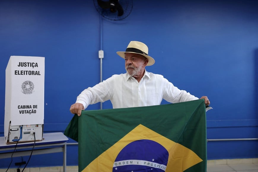 Brazilian President and Workers' Party (PT) candidate for re-election Luiz Inacio Lula da Silva holds the national flag as he arrives to vote in the general election in Sao Bernardo do Campo, Brazil, October 4, 2026. REUTERS/Amanda Perobelli