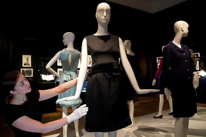 FILE PHOTO: An employee poses as she adjusts a Givenchy cocktail gown worn in the film Charade in 1963 by Audrey Hepburn, and one of the actresses personal collection to go on pre-sale exhibition ahead of it's auction on September 27 at Christie's in central London, Britain September 22, 2017. REUTERS/Toby Melville - /File Photo francia paris muerte modisto de la alta costura francesa vestuario vestidos usados en la pelicula charada