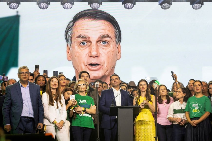 FILE PHOTO: An AI-made video showing former President of Brazil Jair Bolsonaro is displayed in the background as Brazilian Senator Flavio Bolsonaro and supporters attend the national convention of the Liberal Party (PL) in Sao Paulo, Brazil, July 25, 2026. REUTERS/Bia Borges/File Photo