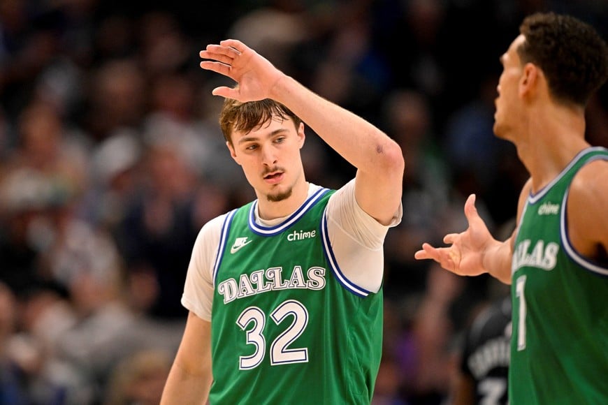 Apr 3, 2026; Dallas, Texas, USA; Dallas Mavericks forward Cooper Flagg (32) and forward Dwight Powell (7) celebrates Flagg making a three point basket against the Orlando Magic during the second half at the American Airlines Center. Mandatory Credit: Jerome Miron-Imagn Images