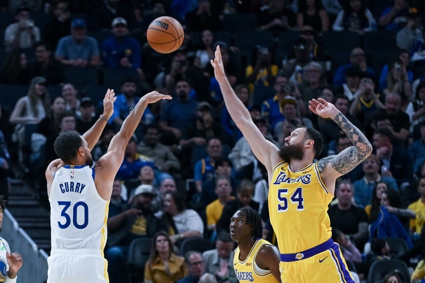 Oct 6, 2026; San Francisco, California, USA;  Golden State Warriors guard Stephen Curry (30) takes a three point shot against Los Angeles Lakers forward/center Sandro Mamukelashvili (54) during the second quarter at Chase Center.  Mandatory Credit: Ed Szczepanski-Imagn Images