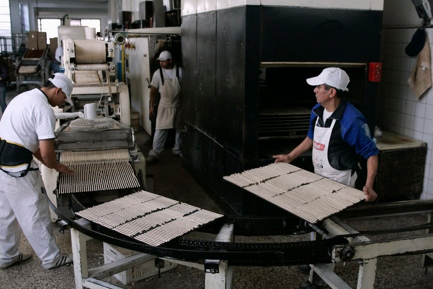 Workers prepare trays of bread-stick at the Grissinopoli factory in Buenos Aires, September 15, 2011. The comeback story of Grissinopoli, a bread-stick factory in Argentina, has a lot in common with the country's own economic renaissance. Picture taken September 15, 2011. To match Insight ARGENTINA-ELECTION/JOBS. REUTERS/Martin Acosta (ARGENTINA - Tags: BUSINESS POLITICS FOOD) buenos aires fabrica de grisines Grissinopoli economia trabajo trabajadores