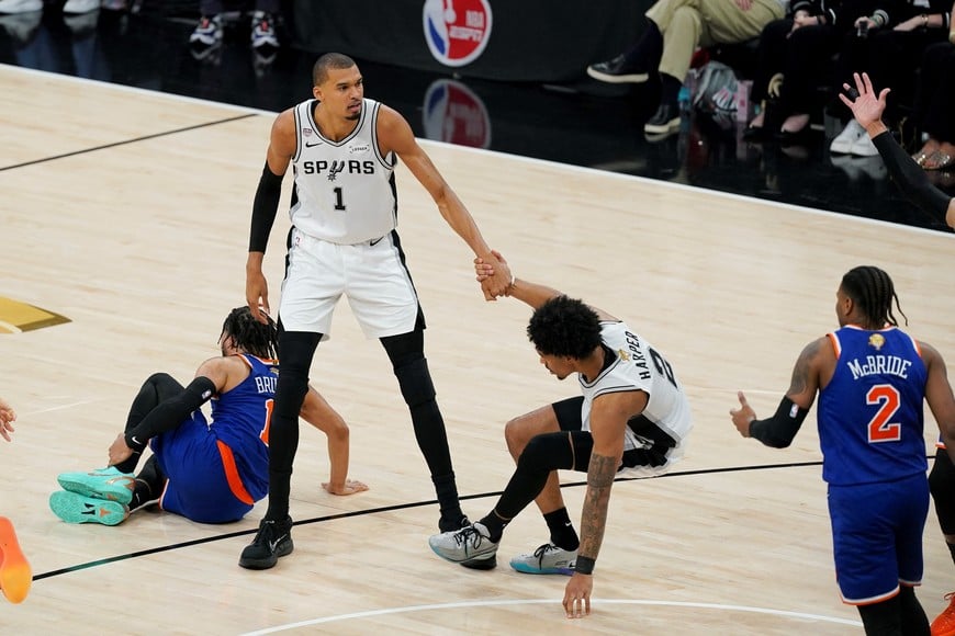 Jun 13, 2026; San Antonio, Texas, USA; San Antonio Spurs forward Victor Wembanyama (1) helps up guard Dylan Harper (2) during the third quarter during game five of the 2026 NBA Finals at Frost Bank Center. Mandatory Credit: Dustin Safranek-Imagn Images
