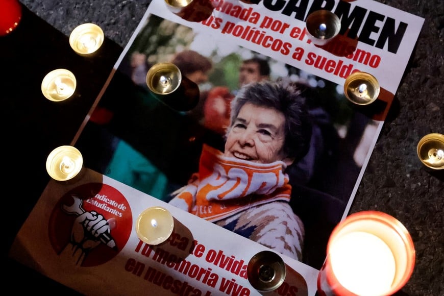 Lit candles sit next to a flyer bearing a picture of Maricarmen Abascal, the 87-year-old woman whose eviction sparked housing protests in Spain, following her death in Madrid, Spain, October 7, 2026. REUTERS/Violeta Santos Moura
