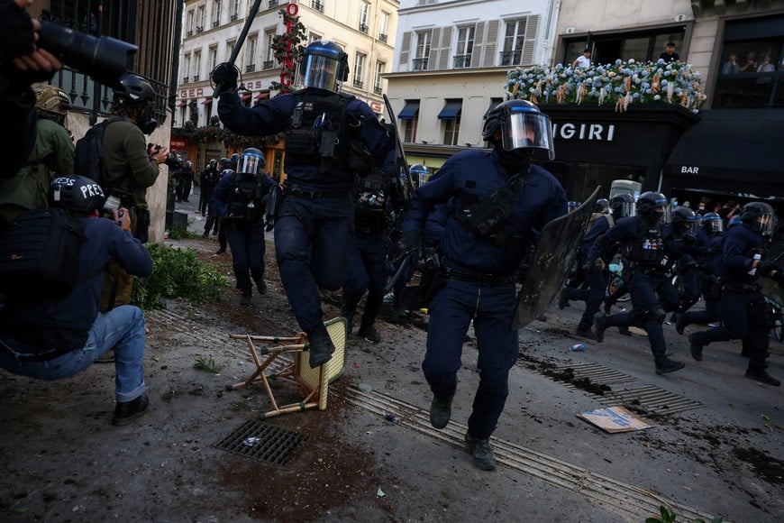 Police officers in riot gear run amid clashes with demonstrators during nationwide protests in Paris, France, October 8, 2026, to demand better school conditions. REUTERS/Pedro Nunes