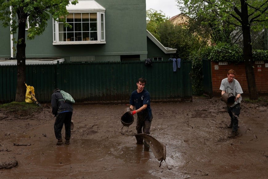 People clear mud after heavy rains triggered a mudslide in Santiago, Chile, October 9, 2026. REUTERS/Pablo Sanhueza