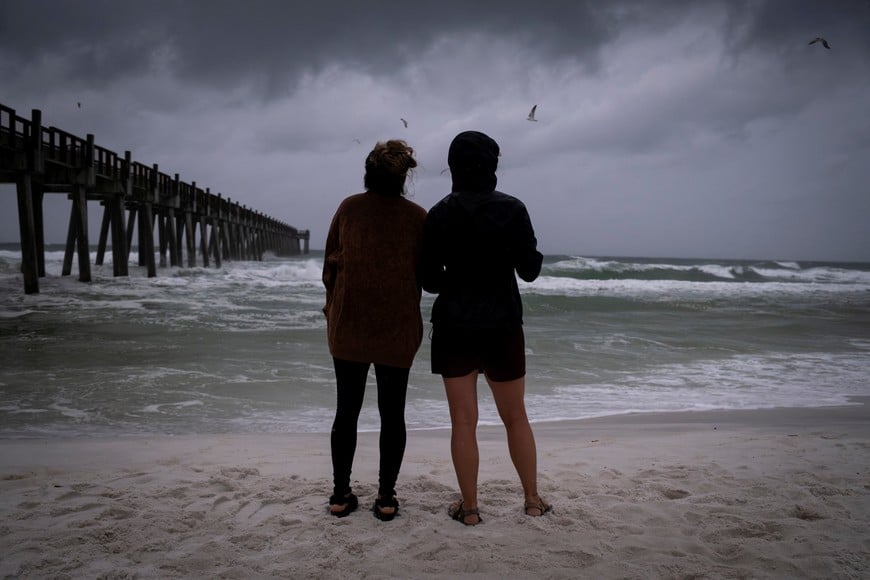 People look at waves in the coastline as Hurricane Isaias moves through the Gulf of Mexico and is forecast to strengthen before reaching the US Gulf Coast, in Pensacola Beach, Florida, US, October 9, 2026. REUTERS/Marco Bello